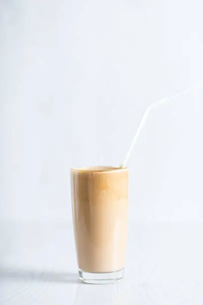 ready-made drink dalgon from instant coffee, sugar, water and milk. Korean fluffy creamy whipped coffee. Cold dalgonacoffee coffee in a glass on a light background. Iced coffee. object at the bottom of the frame. Copyspace..