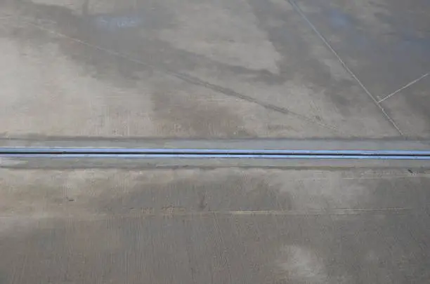 Photo of expansion joint on the concrete roof which serves as a parking lot. dilatation consists of a rubber strip with a metal stainless steel cover