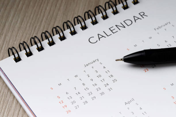 istock White clean calendar and pen on wood  background with copy space 1291187797