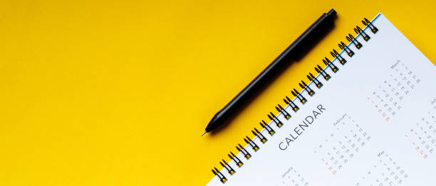 istock White clean calendar and pen  on  yellow background with copy space 1291187884