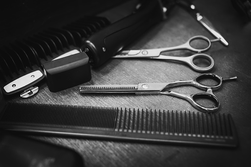 metal scissors and black combs for haircuts are in the hairdresser