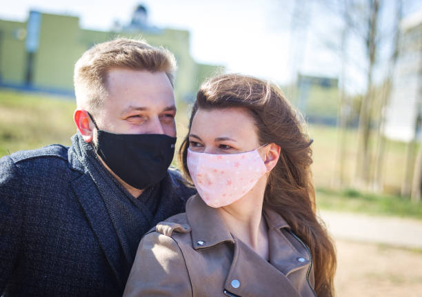 istock Masked young couple walking in the park 1291189179