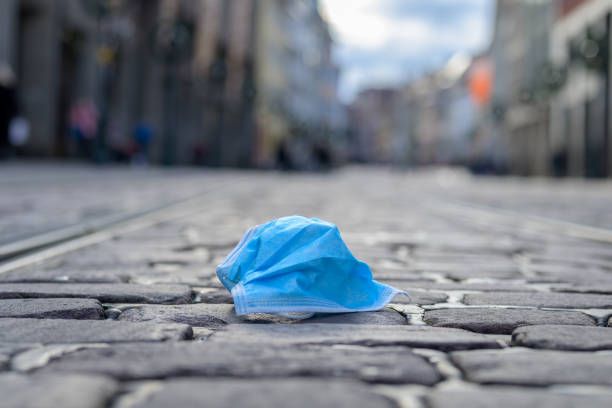 istock Discarded face mask lying in a city street 1291190541