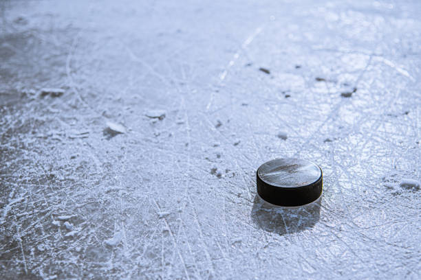 black hockey puck lies on ice at stadium - ice hockey hockey puck playing shooting at goal imagens e fotografias de stock