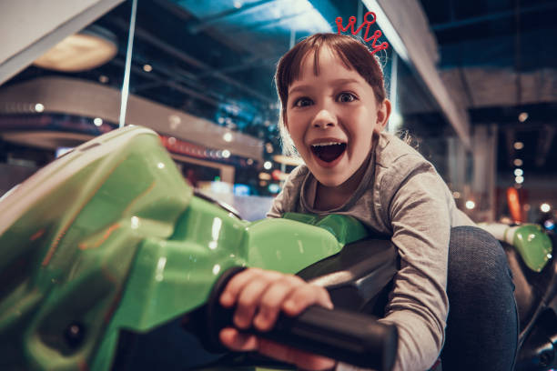 Little Girl on Toy Motorcycle in Amusement Center stock photo