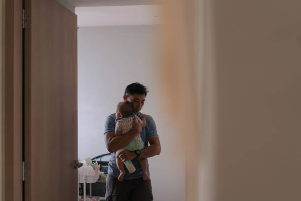 Asian father comforts his baby in his arms Asian father comforts his baby in his arms father and baby stock pictures, royalty-free photos & images