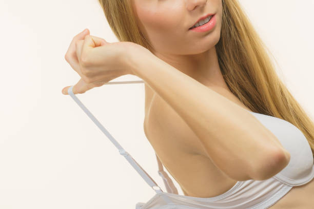 Young woman holding bra strap