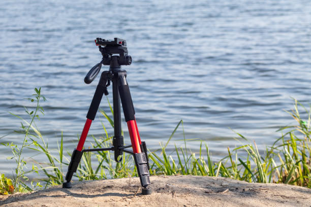 istock Camera red tripod low position standing near blue water 1291194588