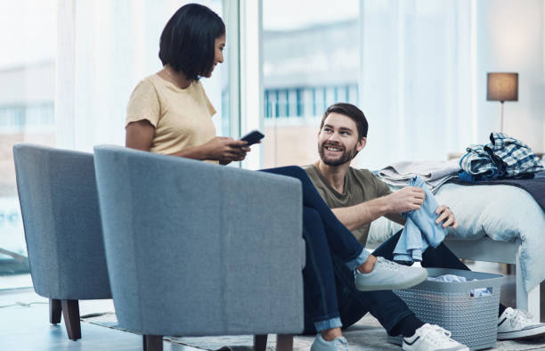 Household work isn’t gender specific Shot of a young couple doing laundry together at home laundry husband housework men stock pictures, royalty-free photos & images