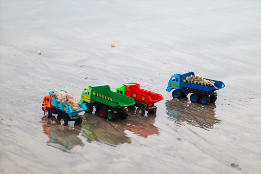 Four toy car parked at the beach waitung for their master