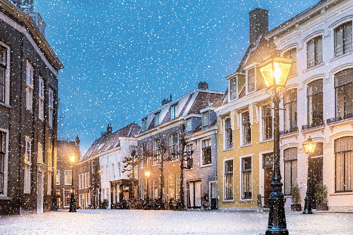Winter view with snowfall of houses on the Pieterskerkhof in the old Dutch city center of Leiden