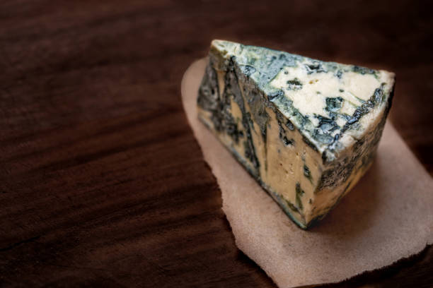 istock Blue cheese Gorgonzola on a dark wooden background. Mold cheese with copyspace. Fresh  typical italian blue cheese close up