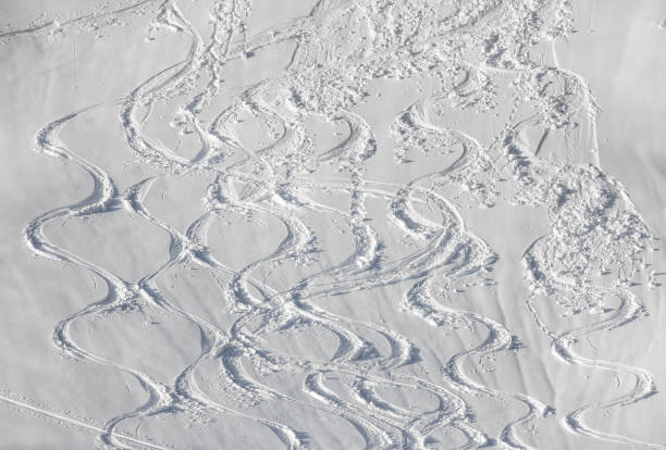 wellvy skitracks im tiefschnee auf verschneiter bergpiste. weißer winter sport hintergrund. - ski track stock-fotos und bilder