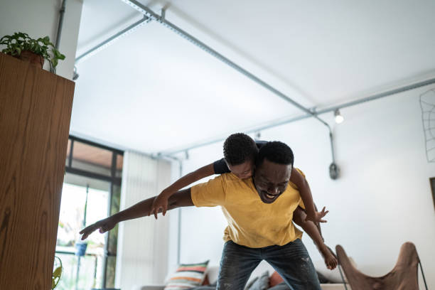 istock Child playing on father's back at home 1291200348