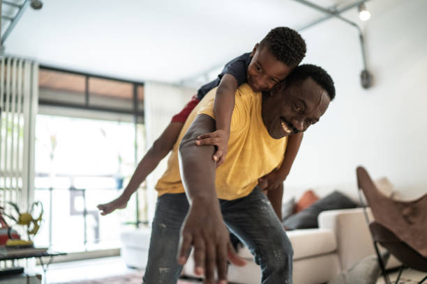 istock Child playing on father's back at home 1291200387