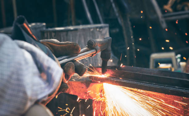 istock Blur Close up hand heavy industrial worker is working on metal work factory process by Cutting sheet steel with gas cutting machine cutting thick steel 1291202069