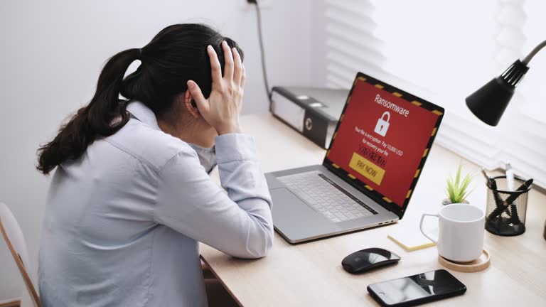 Businesswoman working on a laptop waits for loading computer and finds out it is infected by a ransomware spyware virus