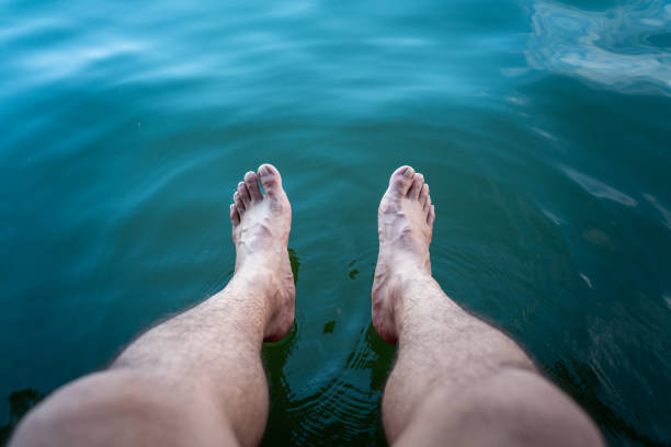 Close-up at human bare foot which is soaking in clearly turquoise water for relaxing. Travel and holiday vacation abstract photo concept.