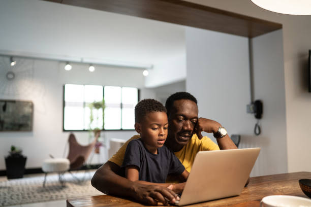 istock Grandfather helping grandson studying or working at home 1291203398