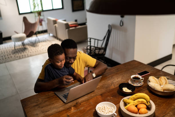 istock Grandfather helping grandson studying or working at home 1291204300