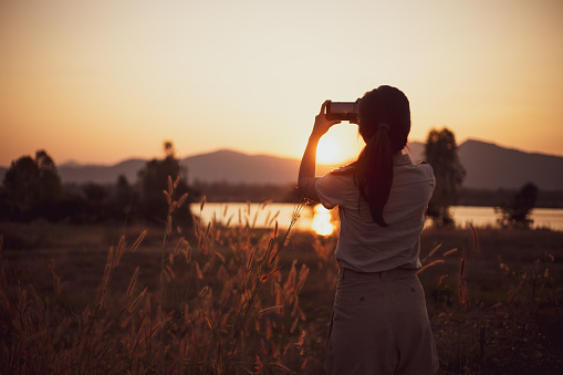 Girl Happy taking pictures with sunset inwinter