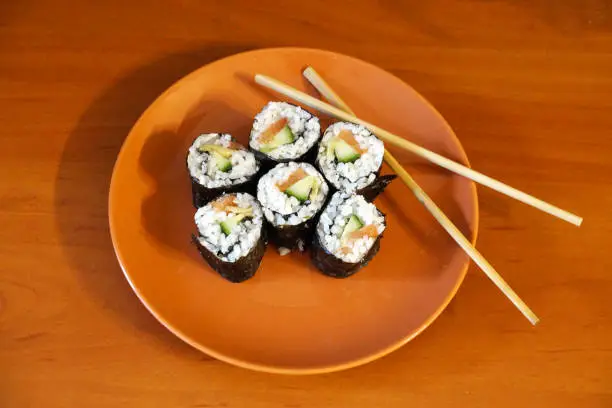 Photo of Japanese sushi and wooden sticks on a plate