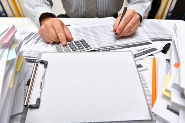 istock business concept, blank paper sheet with copy space for text - businessman working with reports in office, table and workspace close view, analyzing financial data, writes and counts 1291206527