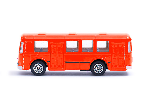 Plastic model of an old red bus, toy, miniature isolated on white