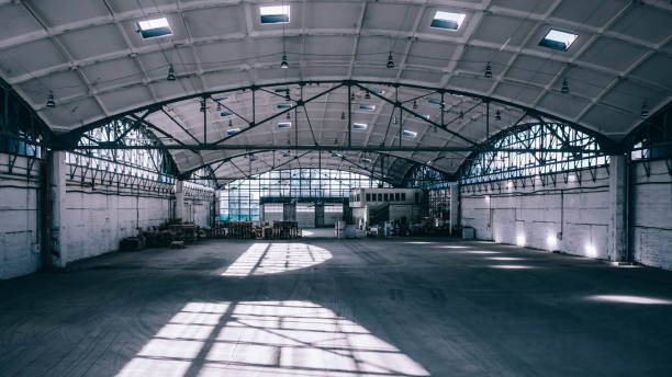 istock Huge industrial warehouse. Modern interior. Unique architecture. Hemispherical reinforced concrete load bearing roof. Stack wooden pallets. 1291208012