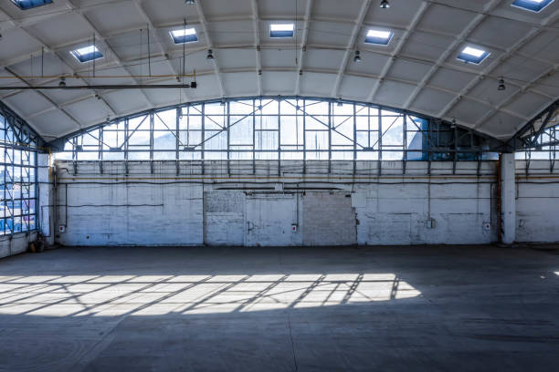 istock Wall of huge empty industrial warehouse. Modern interior. Unique soviet architecture. Hemispherical reinforced concrete load bearing roof. 1291208039