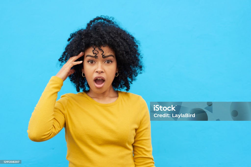 Are you serious? Shot of a woman looking astonished while posing against a blue background Surprise Stock Photo