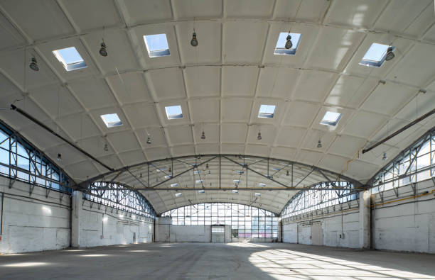 istock Huge empty industrial warehouse. White interior. Unique architecture. Hemispherical reinforced concrete load bearing roof with windows. Modern building. 1291208333