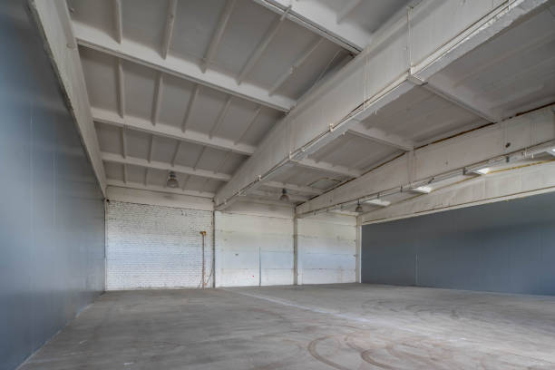 istock Modern interior of huge empty concrete industrial warehouse. White brick wall. 1291208379