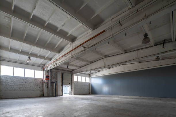 istock Modern interior of huge empty concrete industrial warehouse. White brick wall. 1291208394