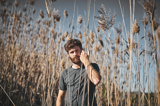 Portrait of a handsome young man standing in a wheat field