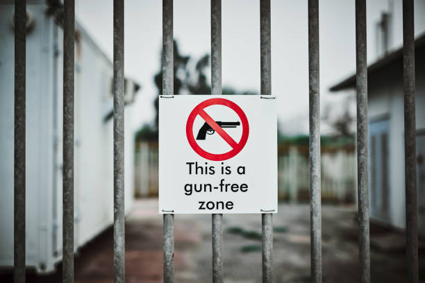 Pay attention to the warning or pay the price Shot of a sign on a fence saying “This is a gun-free zone” gun control photos stock pictures, royalty-free photos & images