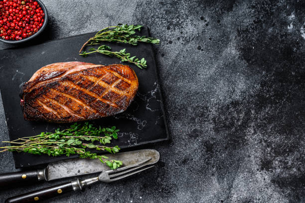istock Roasted Christmas duck breast fillet steak. Black background. Top view. Copy space 1291209031