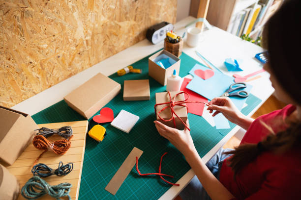 istock Unrecognizable woman making creative cardboard boxes for presents 1291209824