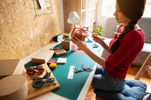 istock Young woman siting at her work table and making creative craft boxes 1291209837