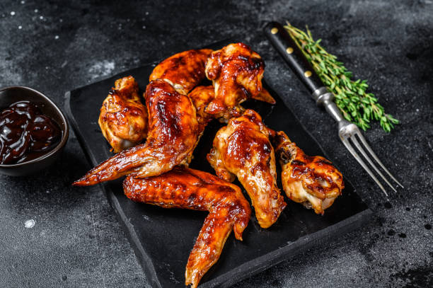 istock Hot Barbecue chicken wings with sauce bbq. Black background. Top view 1291211202