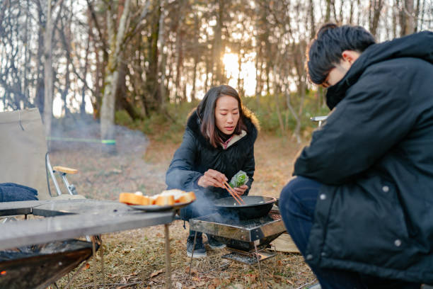 istock Friends preparing breakfast at camp site in winter 1291216337