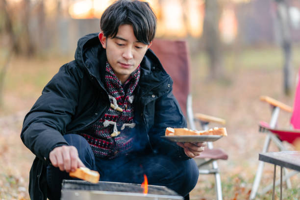 istock Young man preparing breakfast at camp site in winter 1291219629