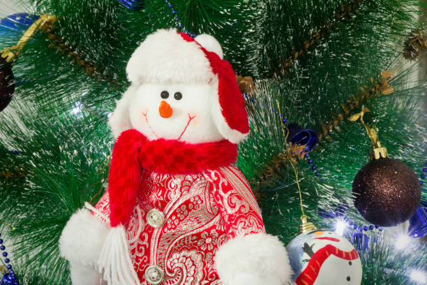 istock Amusing figure of a snowman on a Christmas fir-tree. 1291229363