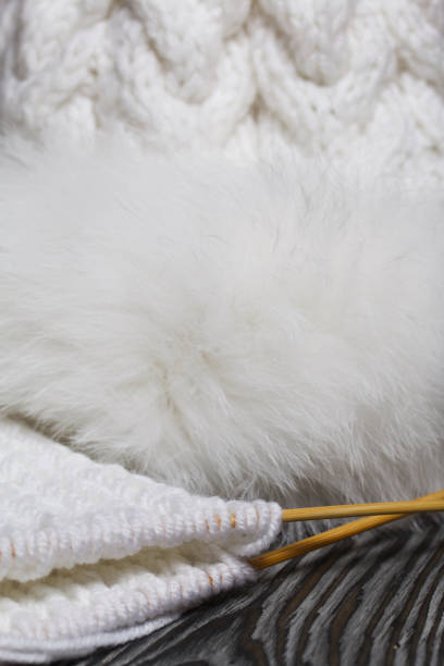 istock Knitting with needles. Wooden knitting needles and white threads. On black pine boards. 1291232629