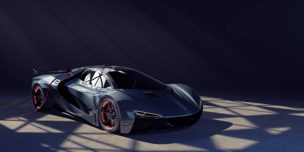 electric sports car charging in dark garage lit from skylight - coche del futuro fotografías e imágenes de stock