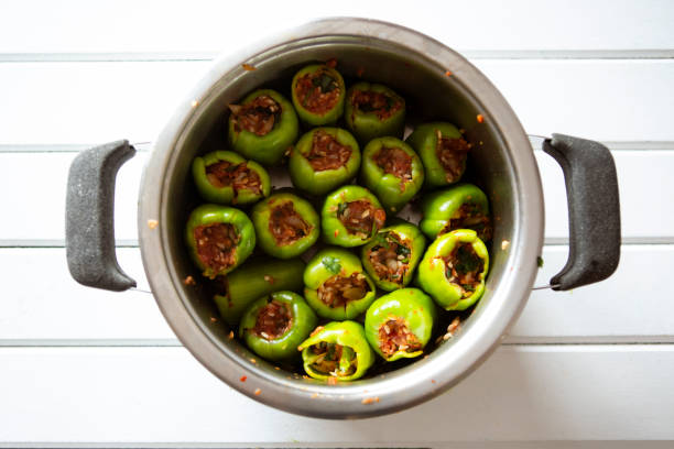 Female hands holding uncooked stuffed peppers