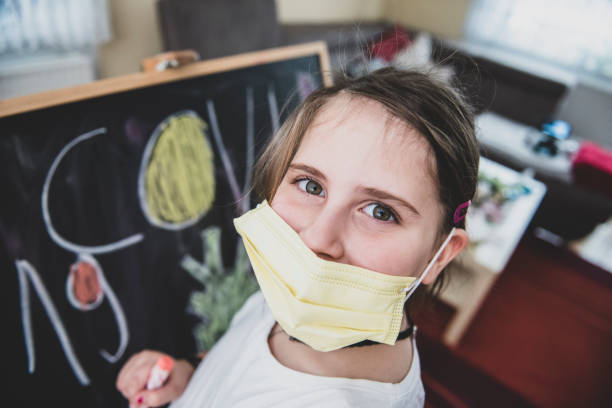 istock Cute little girl is drawing on blackboard 1291234320