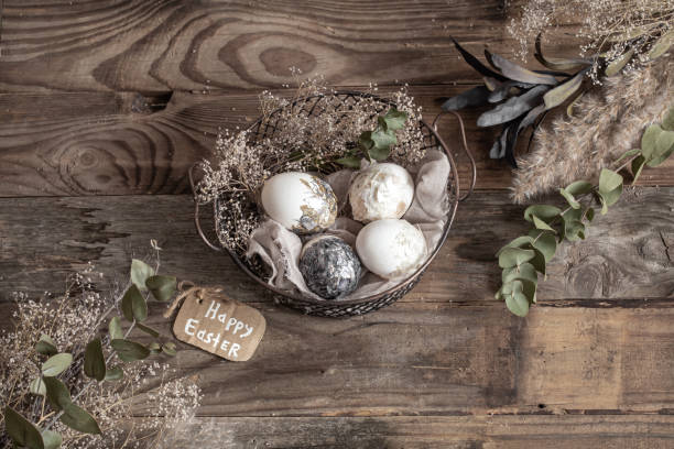 istock Easter composition with decorative eggs in a basket on a wooden surface. 1291237468