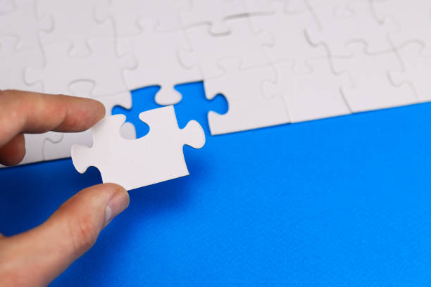 istock missing piece of the puzzle is inserted by the hand into its place 1291237671