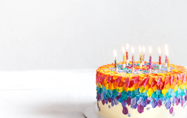 istock Colorful handmade birthday cake with burning candles copy space. 1291237712